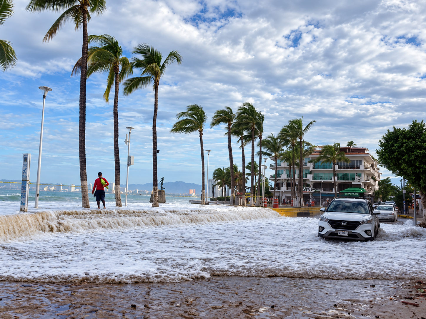 Storm surf flooding a palm-lined Puerto Vallarta road after Hurricane Rachel swell